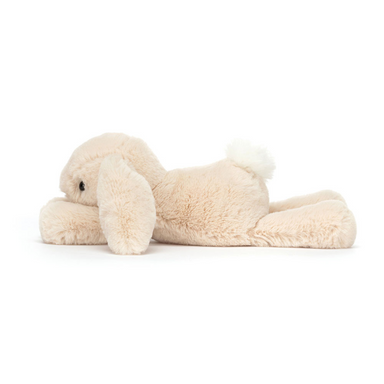 Jellycat Tiny Smudge Rabbit plush has a cream body, pink nose and white fluffy tail. Side view lying down